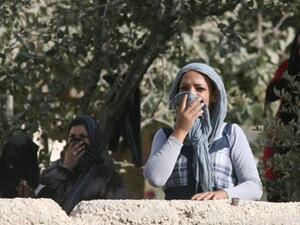 فلسطينيات يغطين انوفهن بسبب كثافة الغاز المسيل للدموع الذي القته قوات الاحتلال على نشطاء يجمعون الزيتون في قرية بيت امر في الخليل/أ.ف.ي