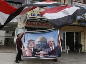 فلسطيني يعرض صورة كبيرة لرئيس الحكومة المقالة اسماعيل هنية ورئيس السلطة الفلسطينية محمود عباس بعد اعلان التوصل الى اتفاق مصالحة