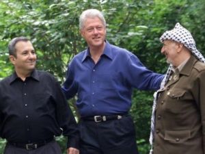 الرئيس الاميركي (السابق) بيل كلينتون يتوسط رئيس الوزراء الاسرائيلي (السابق) ايهود باراك (يسار) والزعيم الفلسطيني (الراحل) ياسر عرفات في كامب ديفيد في 11 تموز/يوليو 2000
