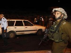 جندي اسرائيلي قرب السيارة التي تعرضت للهجوم