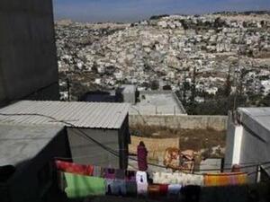 امراة فلسطينية تقف في منزلها قبالة جبل المكبر في القدس الشرقية