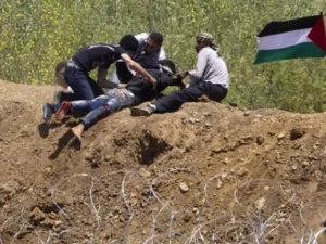 متظاهرون فلسطينييون ينقذون شابا أصيب بالرصاص الإسرائيلي على حدود الجولان 