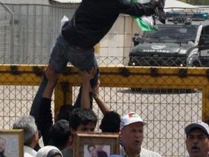 متظاهر يعلق علما فلسطينيا على باب سجن عوفر الاسرائيلية في الضفة
