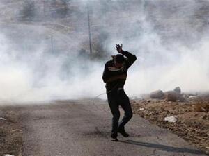 فلسطيني يفر هربا من عبوة غاز مسيل للدموع اطلقها الجيش الاسرائيلي قرب رام الله 