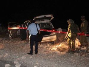 عناصر من الامن الاسرائيلي يتفقدون السيارة التي تعرضت للهجوم قرب رام الله