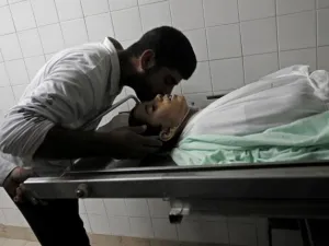 احد اقرباء الطفل الشهيد يقبله في مستشفى خان يونس/أ.ف.ب
