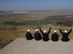 Druze men at the Israeli-annexed Golan Heights flash the V for victory sign as they look out across the southwestern Syrian province of Quneitra on July 7, 2018. (Jalaa Marey/AFP/Getty Images) 
