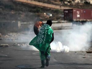 متظاهر يرتدي راية حماس خلال تظاهرة في بتونيا في الضفة الغربية احتجاجا على "برافر"/أ.ف.ب