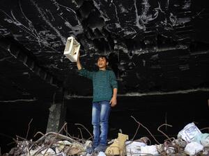 A Palestinian boy plays in the ruins of a building that was destroyed in the 2014 war between Israel and Hamas militants, in Gaza City, on February 16, 2016. (AFP/Mohamed Abed) 