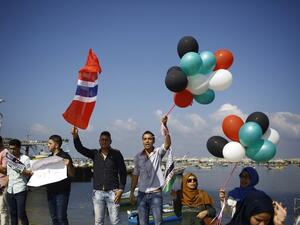 Palestinians show their solidarity with a Gaza-bound flotilla of international activists attempting to break the Israeli blockade on the Hamas-run Gaza Strip, on October 5, 2016 at the port in Gaza City. (AFP/Mohammed Abed)
