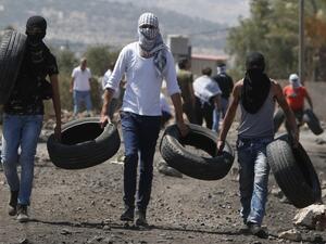 Palestinian protestors burn tires during clashes with Israeli security forces following a weekly demonstration against the expropriation of Palestinian land by Israel in the village of Kfar Qaddum, near Nablus in the occupied West Bank, on September 9, 2016. (AFP/Jaafar Ashtiyeh)