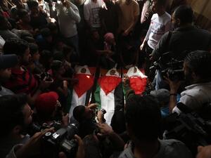 Palestinian mourners gather around the bodies of three Palestinian teenagers killed last night in an Israeli strike. (AFP/ MAHMUD HAMS)