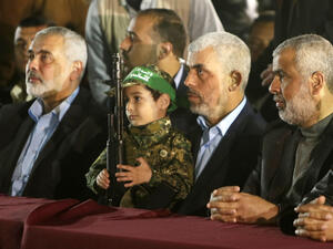 Hamas' leader, Yahya Sinwar, sits second from right at a memorial for assassinated Hamas leader Mazen Fuqaha. (AFP/Mahmud Hams)