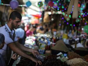 A Palestinian woman buys dates at a market in Gaza City as the faithful prepare for the start of the Muslim holy fasting month of Ramadan on June 17, 2015. (AFP/Mahmoud Hams)