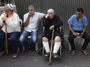 Members of the Shamasneh family sit outside their home after being evicted (Ahmad Gharabli/AFP)