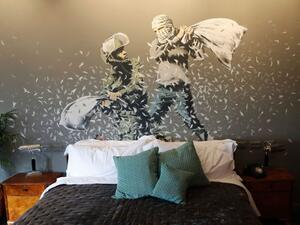 A picture shows a bed and graffiti inside street artist Banksy's newly opened Walled Off hotel in the Israeli occupied West Bank town of Bethlehem, on March 3, 2017. (AFP/Thomas Coex) 