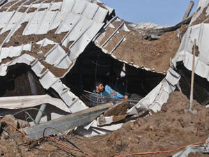 Palestinians try to pull out chickens after a roof collapsed over livestock in the strike. (Twitter)
