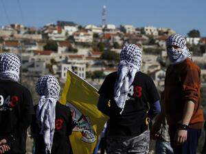 This file photo taken on December 30, 2016 shows Palestinian protestors stand facing the Israeli settlement of Qadumim (Kedumim) during clashes with Israeli security forces following a demonstration against the expropriation of Palestinian land by Israel in the village of Kfar Qaddum, near Nablus, in the occupied West Bank. (AFP/Jaafar Ashtiyeh)