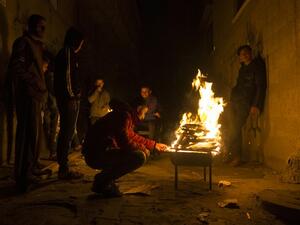 Palestinians gather around a fire during a power cut in the Al-Shati refugee camp in Gaza City, on January 4, 2017. (AFP/Mahmud Hams)