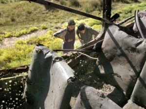 KHALIS : Iraqi boys looks at a bus that was hit by a roadside bomb 29 May 2006 in the town of Khalis, northeast of Baghdad. Eleven people were killed 11 others were wounded in the attack. 