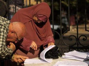 EGYPT, Cairo : An Egyptian man checks for the name of his wife at the entrance of a polling station in Cairo on November 28, 2010, as polls opened across Egypt for a parliamentary election expected to strengthen the ruling party's grip in the most populous Arab nation but marred by a crackdown on the Islamist opposition.