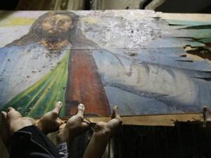 Egyptian Christians hold a blood-stained portrait of Jesus Christ during a protest late on January 2, 2011 outside the Al-Qiddissine (The Saints) church in Alexandria, following a New Year's Eve car bomb attack on the Coptic church in the northern Egyptian city in which 21 people were killed.