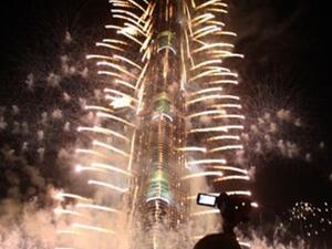 Crowds look at fireworks bursting around Burj Khalifa, the tallest building in the world, marking the New Year at midnight on January 1, 2011 in the Gulf emirate of Dubai. 