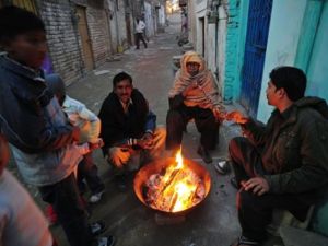 Islamabad : Pakistani Christian warm themselves around a fire in the slum area of Islamabad