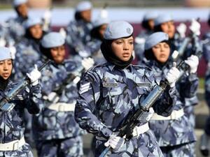 Qatari women and members of the armed forces take part in a military parade during National Day celebrations in Doha on December 18, 2010