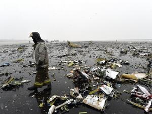 Russian emergency rescuer walks through wreckage of the flydubai passenger jet which crashed, killing all 62 people on board as it tried to land in bad weather in the city of Rostov-on-Don on March 19, 2016. (AFP)