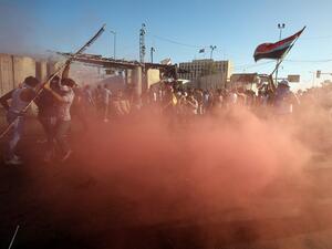 Sadrist protesters outside of Baghdad's Green Zone react to canisters of tear gas. (AFP/Ahmad Al-Rubaye) Sadrist protesters outside of Baghdad's Green Zone react to canisters of tear gas. (AFP/Ahmad Al-Rubaye)