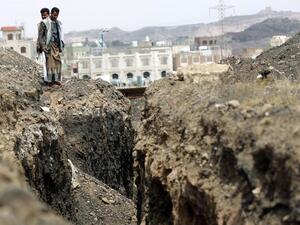 Men stand by a crater in Sanaa, Yemen in 2014. (AFP Photo/Mohammed Huwais)