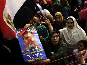 Opposition protesters shout slogans and show a defaced poster of their president as they gather in thousands at the Presidential Palace to protest against Egyptian President Mohamed Morsi and the Muslim Brotherhood (Source: AFP/GIANLUIGI GUERCIA)