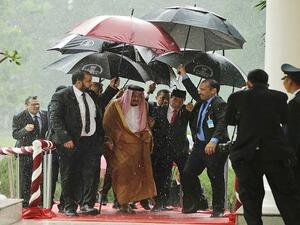  الرئيس الإندونيسي يحمل المظلة للملك سلمان بن عبد العزيز 