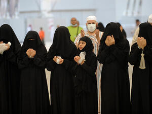 Muslim pilgrims recite prayers after throwing pebbles at pillars in the "Jamarat" ritual which symbolizes the stoning of Satan on the third day of the Eid Al-Adha holiday in Min. (Image credit: AFP)