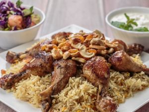 Mandi, a traditional rice dish popular in the Gulf, is served with chicken or lamb and topped with cashews and dried fruit. (Shutterstock)
