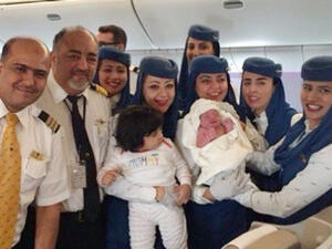 The Saudi Arabian Airlines crew are pictured holding the newborn baby girl who was born on a flight from Jeddah to New York. (Twitter)