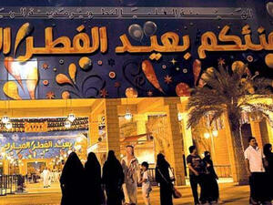 Saudis under a “Happy Eid” banner outside a government building in Riyadh’s Masmak quarter on the eve of the end of the fasting month of Ramadan. (AFP/ File photo)
