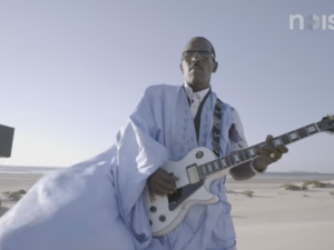 A screenshot from the music video for 'Doueh Shreds in the Moroccan Desert: Guitar Moves.' (YouTube)