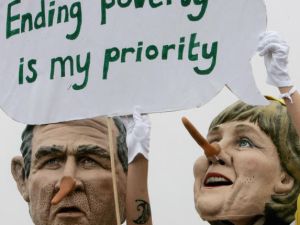 Demonstrators in face masks of world politicians carrying their slogans.