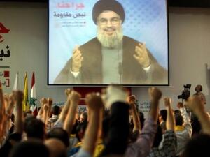 Supporters of Hassan Nasrallah (portrait), the head of Lebanon's militant Shiite Muslim movement Hezbollah raise their fists as they watch him giving a televised address in Beirut last week (AFP)