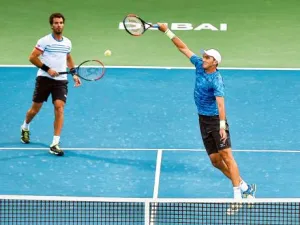 Horia Tecau powers a smash as his partner Jean-Julien Rojer watches during their men’s doubles final against Rohan Bopanna and Marcin Matkowski atDubai Tennis Stadium. (Photo: Ahmed Ramzan/Gulf News)