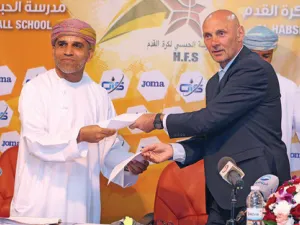 Andy Watson (right) and Suleiman al Habsi exchange agreement papers after the Scotsman was hired as HFS technical director on Sunday (Photo: Muscat Daily)