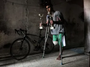 Palestinian cyclist Alaa Al-Daly, 21, who lost his leg by a bullet fired by Israeli troops along the Gaza border during a protest, stands next to his bicycle holding trophies he has won in competitions, at his home in Rafah in the southern Gaza Strip on April 19, 2018. Daly's dream of competing for Palestine at the Asian Games has been shattered after the athletes right leg was amputated after being shot by Israeli soldiers during recent demonstrations in Gaza.
SAID KHATIB / AFP
