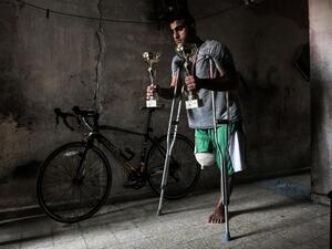 Palestinian cyclist Alaa Al-Daly, 21, who lost his leg by a bullet fired by Israeli troops along the Gaza border during a protest, stands next to his bicycle holding trophies he has won in competitions, at his home in Rafah in the southern Gaza Strip on April 19, 2018. Daly's dream of competing for Palestine at the Asian Games has been shattered after the athletes right leg was amputated after being shot by Israeli soldiers during recent demonstrations in Gaza.
SAID KHATIB / AFP