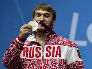 Russia's Apti Aukhadov poses on the podium with his silver medal, during the men's 85kg group A weightlifting event of the London 2012 Olympic Games at The Excel Centre in London on August 3, 2012. YURI CORTEZ / AFP