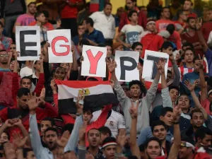 Egyptian fans carry placards and the national flag ahead of the match between Egypt and Senegal during the Africa Cup of Nations group G football match at the Cairo International Stadium in the Egyptian capital on November 15, 2014. AFP PHOTO / KHALED DESOUKI
KHALED DESOUKI / AFP