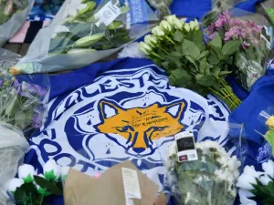 A flag showing the Leicester City Football Club's Fox logo with a message of thanks is seen in a growing pile of tributes outside Leicester City Football Club's King Power Stadium in Leicester, eastern England, on October 28, 2018.
Ben STANSALL / AFP