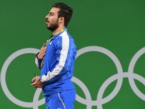 Iran's gold medallist Kianoush Rostami poses on the podium after the men's weightlifting 85kg event during the Rio 2016 Olympics Games in Rio de Janeiro on August 12, 2016.
GOH Chai Hin / AFP
