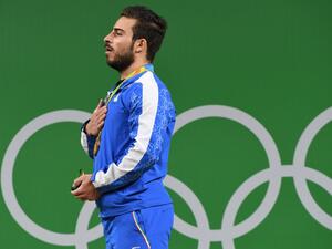 Iran's gold medallist Kianoush Rostami poses on the podium after the men's weightlifting 85kg event during the Rio 2016 Olympics Games in Rio de Janeiro on August 12, 2016.
GOH Chai Hin / AFP